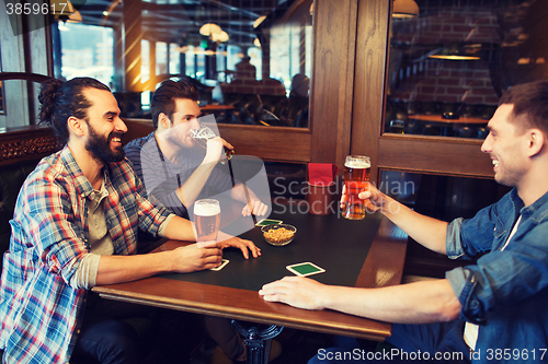 Image of happy male friends drinking beer at bar or pub