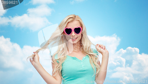 Image of happy young woman in heart shape sunglasses