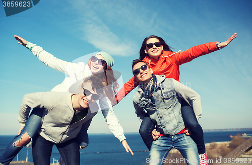 Image of happy friends in shades having fun outdoors