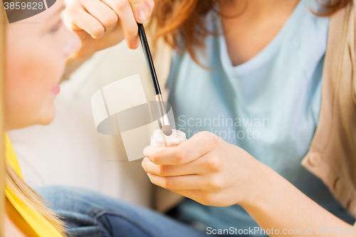 Image of woman visagist applying eyeshade by makeup brush 