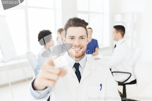 Image of happy doctor over group of medics at hospital