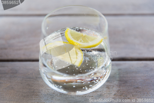 Image of glass of sparkling water with lemon on table