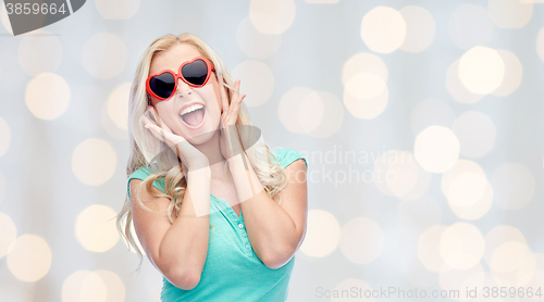 Image of happy young woman in heart shape sunglasses