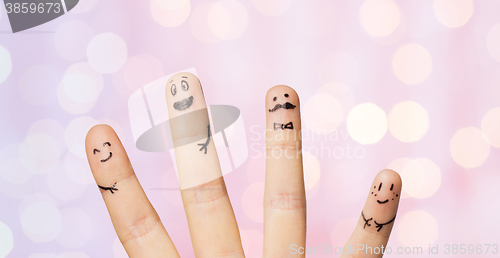 Image of close up of four fingers with smiley faces