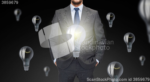 Image of close up of businessman in suit with ligh bulbs