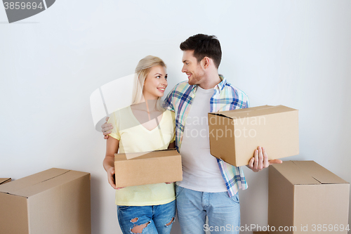 Image of smiling couple with big boxes moving to new home