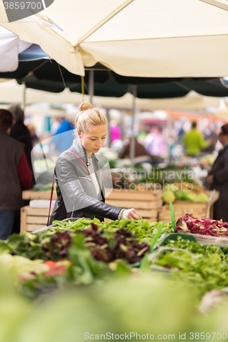 Image of Woman buying vegetable at local food market. 