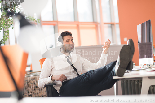 Image of relaxed young business man at office