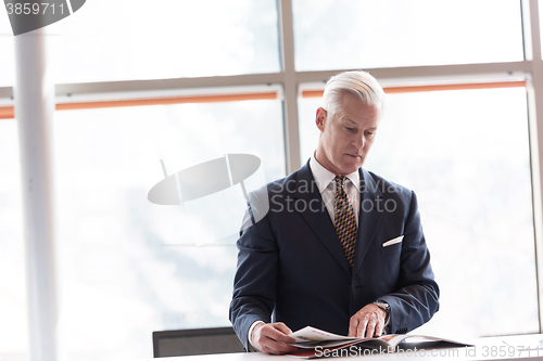 Image of senior business man reading magazine