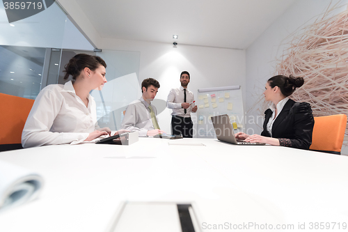 Image of business people group brainstorming and taking notes to flip boa