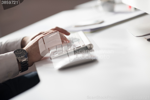 Image of hands typing on desktop computer