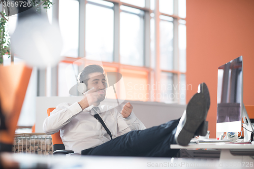 Image of relaxed young business man at office