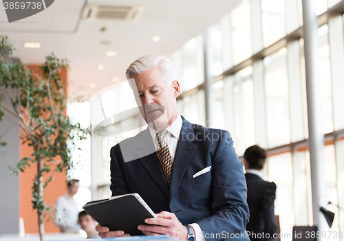 Image of senior business man working on tablet computer