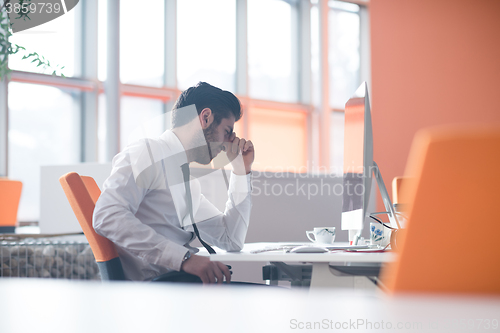 Image of frustrated young business man at work