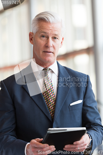 Image of senior business man working on tablet computer