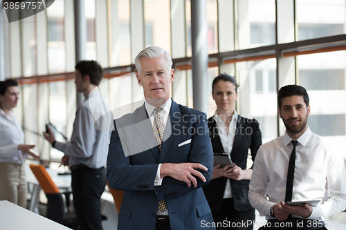 Image of portrait of senior businessman as leader  with group of people i