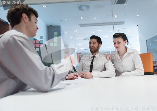 Image of young couple signing contract documents on partners back