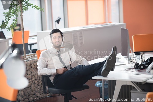 Image of relaxed young business man at office