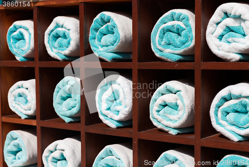 Image of close up of shelf with rolled bath towels