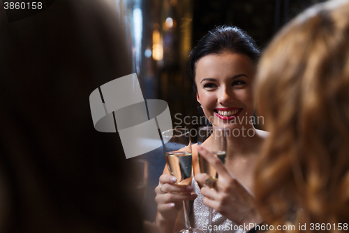 Image of happy women with champagne glasses at night club