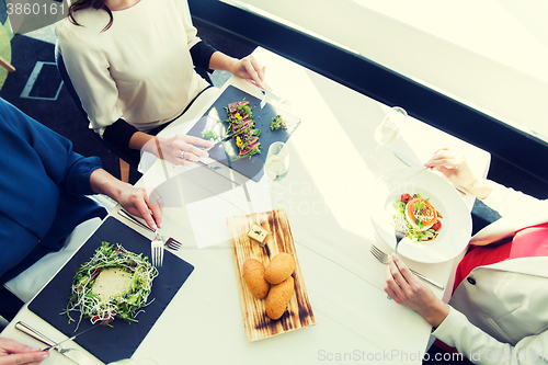 Image of close up of women eating appetizer at restaurant