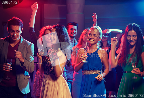 Image of smiling friends with glasses of champagne in club