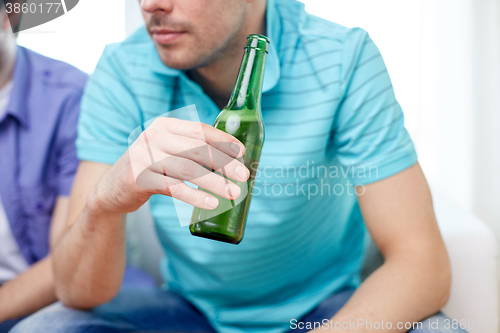 Image of close up of man friends drinking beer at home