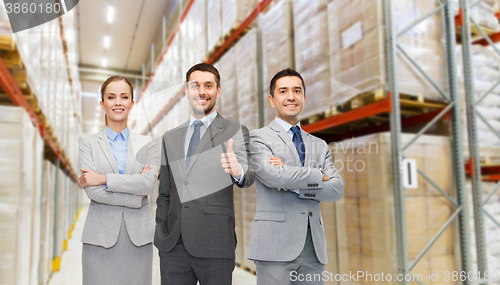 Image of happy business team at warehouse showing thumbs up