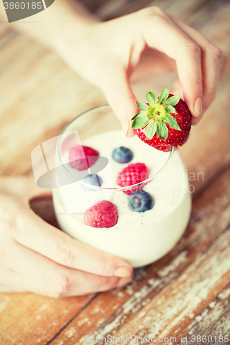 Image of close up of woman hands with yogurt and berries