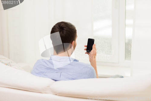 Image of close up of man with smartphone at home