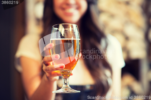 Image of happy woman holding glass of draft lager beer