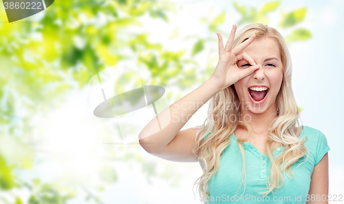 Image of young woman making ok hand gesture