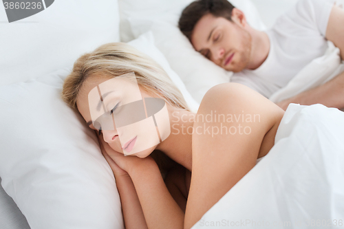 Image of happy couple sleeping in bed at home