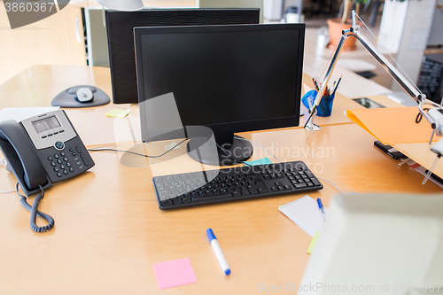 Image of computers with blank black screen on office table