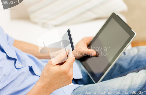 Image of close up of man with tablet pc and credit card