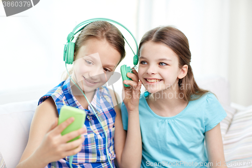 Image of happy girls with smartphone and headphones