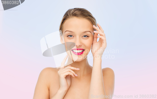 Image of smiling young woman with pink lipstick on lips