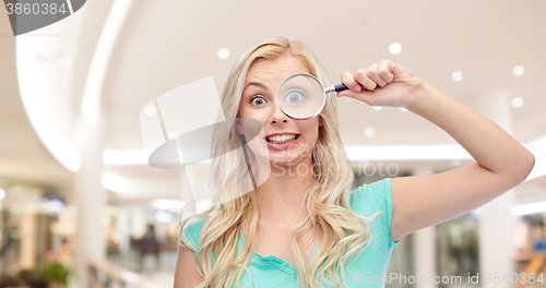 Image of happy young woman with magnifying glass