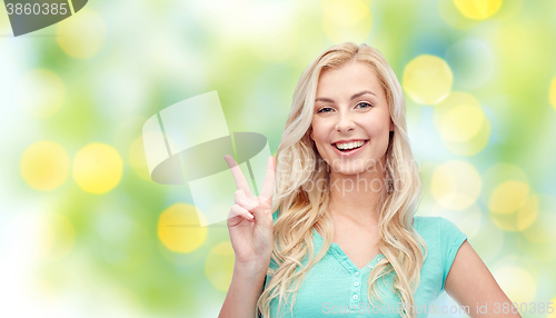 Image of smiling young woman or teenage girl showing peace