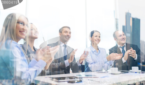 Image of business team with laptop clapping hands