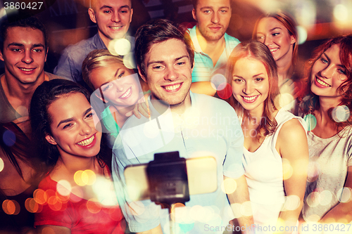 Image of friends with smartphone taking selfie in club