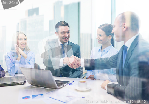 Image of two businessman shaking hands in office