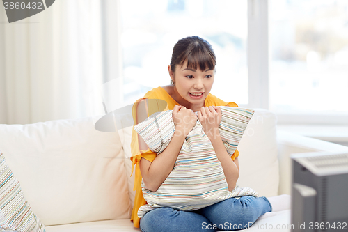 Image of asian young woman watching tv at home