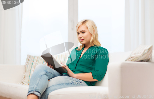 Image of smiling woman with tablet pc at home
