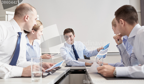 Image of group of smiling businesspeople meeting in office