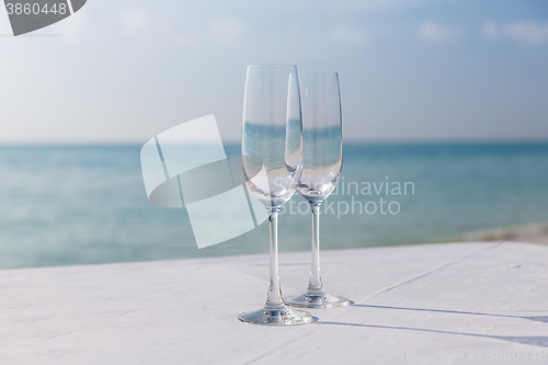 Image of  close up of two champagne glasses on beach 