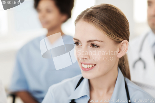 Image of happy doctor over group of medics at hospital