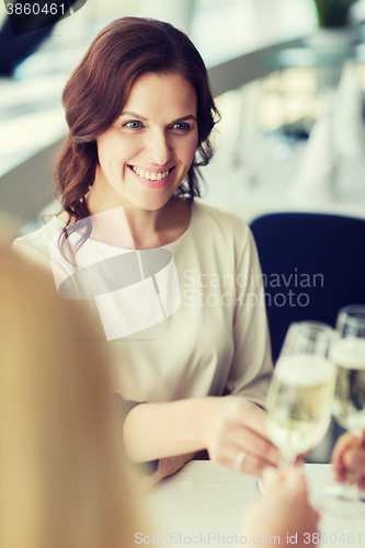 Image of happy women drinking champagne at restaurant