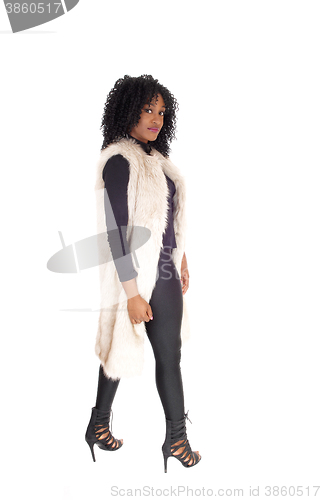 Image of African American woman walking in fur coat.