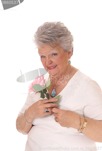 Image of Senior woman holding pink rose.